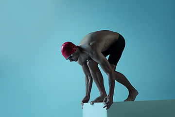 Image showing Professional male swimmer with hat and goggles in motion and action, healthy lifestyle and movement concept. Neoned style.