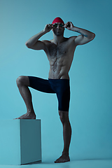 Image showing Professional male swimmer with hat and goggles in motion and action, healthy lifestyle and movement concept. Neoned style.
