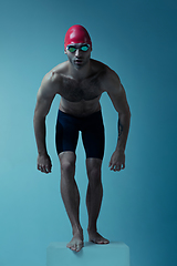 Image showing Professional male swimmer with hat and goggles in motion and action, healthy lifestyle and movement concept. Neoned style.