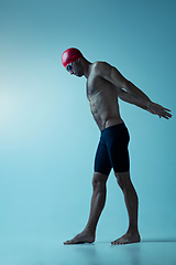 Image showing Professional male swimmer with hat and goggles in motion and action, healthy lifestyle and movement concept. Neoned style.