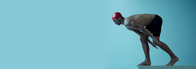 Image showing Professional male swimmer with hat and goggles in motion and action, healthy lifestyle and movement concept. Neoned style.