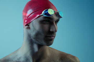 Image showing Professional male swimmer with hat and goggles in motion and action, healthy lifestyle and movement concept. Neoned style.