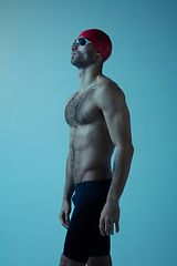 Image showing Professional male swimmer with hat and goggles in motion and action, healthy lifestyle and movement concept. Neoned style.