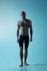 Image showing Professional male swimmer with hat and goggles in motion and action, healthy lifestyle and movement concept. Neoned style.