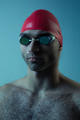 Image showing Professional male swimmer with hat and goggles in motion and action, healthy lifestyle and movement concept. Neoned style.
