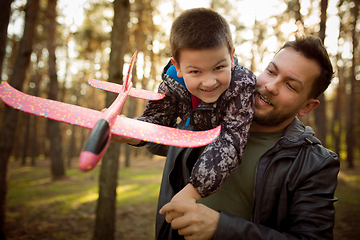 Image showing Father and son walking and having fun in autumn forest, look happy and sincere