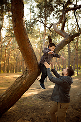 Image showing Father and son walking and having fun in autumn forest, look happy and sincere