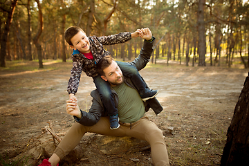 Image showing Father and son walking and having fun in autumn forest, look happy and sincere