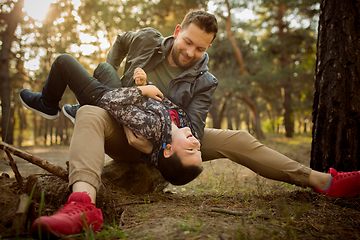 Image showing Father and son walking and having fun in autumn forest, look happy and sincere