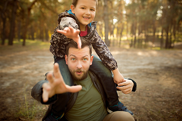 Image showing Father and son walking and having fun in autumn forest, look happy and sincere