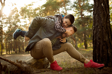 Image showing Father and son walking and having fun in autumn forest, look happy and sincere