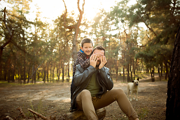 Image showing Father and son walking and having fun in autumn forest, look happy and sincere