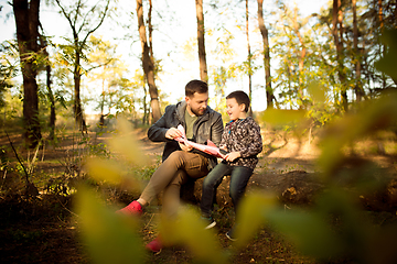 Image showing Father and son walking and having fun in autumn forest, look happy and sincere