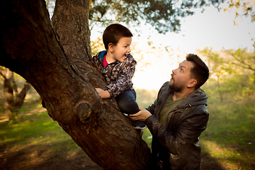 Image showing Father and son walking and having fun in autumn forest, look happy and sincere