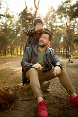 Image showing Father and son walking and having fun in autumn forest, look happy and sincere