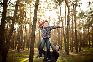 Image showing Father and son walking and having fun in autumn forest, look happy and sincere