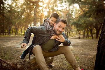 Image showing Father and son walking and having fun in autumn forest, look happy and sincere