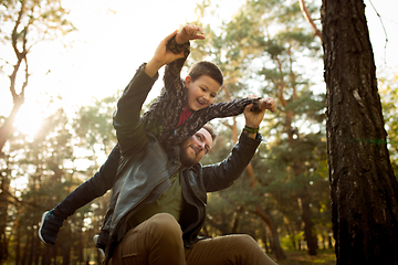 Image showing Father and son walking and having fun in autumn forest, look happy and sincere