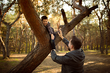 Image showing Father and son walking and having fun in autumn forest, look happy and sincere