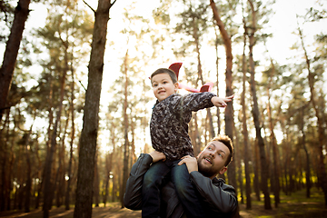 Image showing Father and son walking and having fun in autumn forest, look happy and sincere