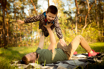 Image showing Father and son walking and having fun in autumn forest, look happy and sincere