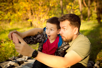 Image showing Father and son walking and having fun in autumn forest, look happy and sincere