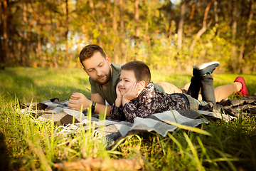 Image showing Father and son walking and having fun in autumn forest, look happy and sincere