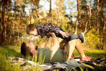 Image showing Father and son walking and having fun in autumn forest, look happy and sincere