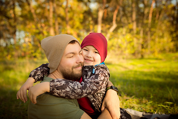 Image showing Father and son walking and having fun in autumn forest, look happy and sincere