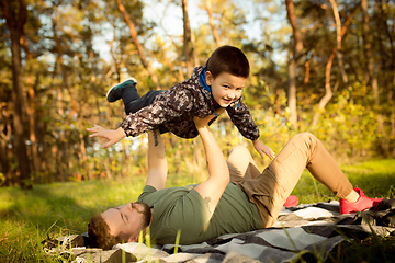 Image showing Father and son walking and having fun in autumn forest, look happy and sincere