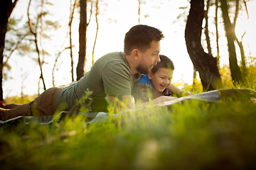 Image showing Father and son walking and having fun in autumn forest, look happy and sincere