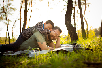 Image showing Father and son walking and having fun in autumn forest, look happy and sincere