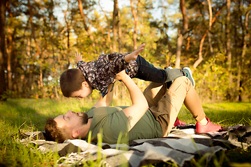 Image showing Father and son walking and having fun in autumn forest, look happy and sincere