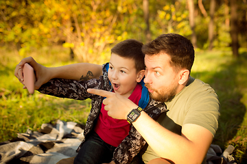 Image showing Father and son walking and having fun in autumn forest, look happy and sincere