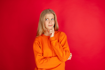 Image showing Portrait of young caucasian woman with bright emotions isolated on red studio background