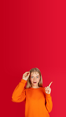 Image showing Portrait of young caucasian woman with bright emotions isolated on red studio background