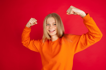 Image showing Portrait of young caucasian woman with bright emotions isolated on red studio background