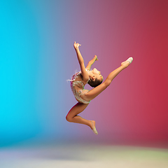 Image showing Little caucasian girl, rhytmic gymnast training, performing isolated on gradient blue-red studio background in neon