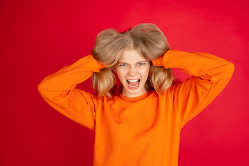 Image showing Portrait of young caucasian woman with bright emotions isolated on red studio background