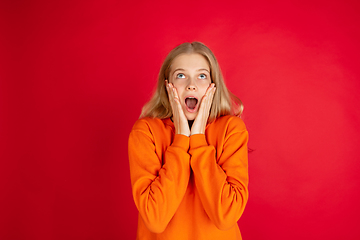 Image showing Portrait of young caucasian woman with bright emotions isolated on red studio background