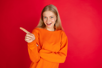 Image showing Portrait of young caucasian woman with bright emotions isolated on red studio background