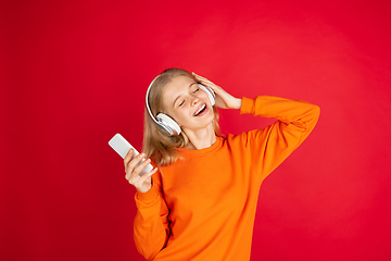 Image showing Portrait of young caucasian woman with bright emotions isolated on red studio background