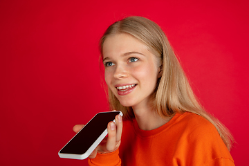 Image showing Portrait of young caucasian woman with bright emotions isolated on red studio background