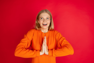 Image showing Portrait of young caucasian woman with bright emotions isolated on red studio background