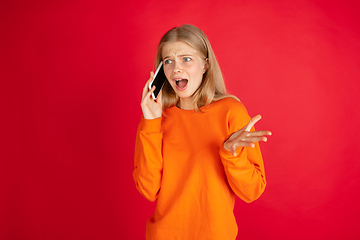 Image showing Portrait of young caucasian woman with bright emotions isolated on red studio background