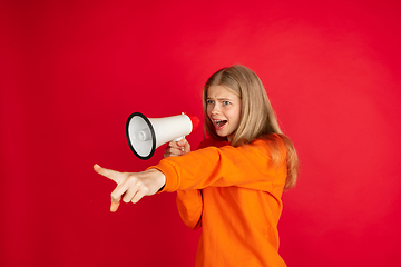 Image showing Portrait of young caucasian woman with bright emotions isolated on red studio background