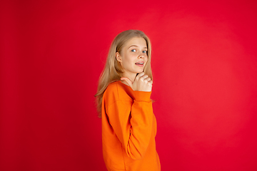 Image showing Portrait of young caucasian woman with bright emotions isolated on red studio background