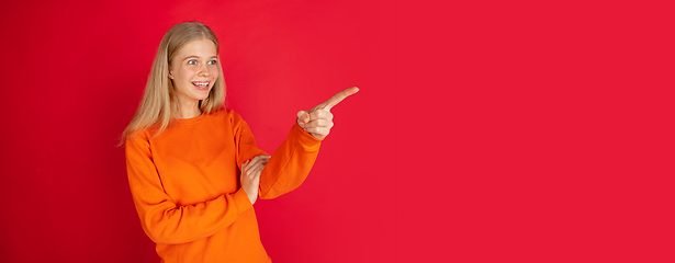 Image showing Portrait of young caucasian woman with bright emotions isolated on red studio background