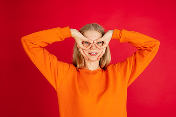 Image showing Portrait of young caucasian woman with bright emotions isolated on red studio background