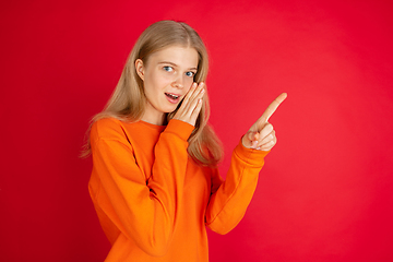 Image showing Portrait of young caucasian woman with bright emotions isolated on red studio background